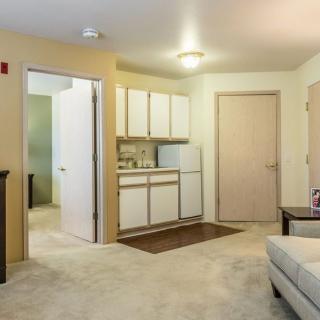 A cozy apartment interior with a living space and kitchenette.