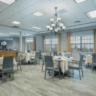 Spacious dining area with elegant chandeliers and neatly arranged tables and chairs.