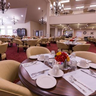 A well-appointed dining room with elegantly set tables and comfortable chairs.