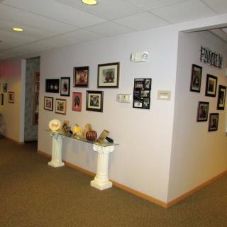 A hallway with art and photographs displayed on the walls.