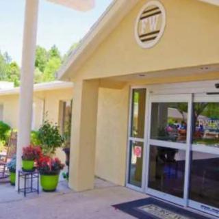 A welcoming building entrance with potted plants and glass doors.