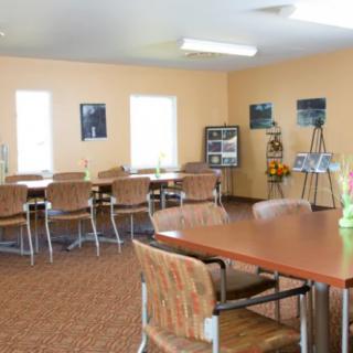A well-lit meeting room with tables and chairs arranged for group discussions.