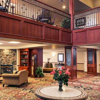 A luxurious hotel lobby featuring elegant wood paneling, plush seating, and a grand chandelier.