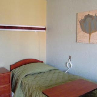 A minimalist hospital room with a single bed and simple decor.