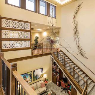 A modern interior featuring a stylish staircase with decorative artwork and ample natural light.