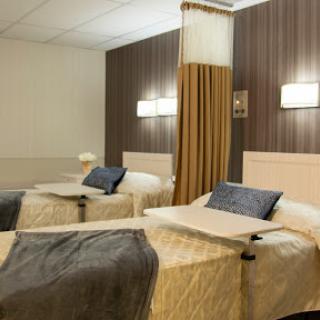 A cozy hotel room featuring two twin beds with elegant decor.