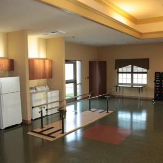 A well-lit rehabilitation room equipped for physical therapy exercises.