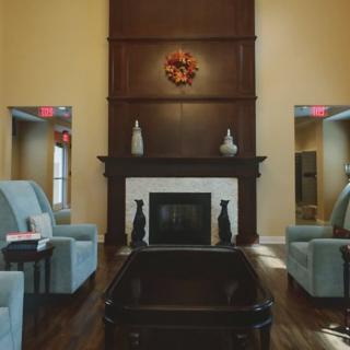 A cozy living room with a central fireplace and comfortable seating.