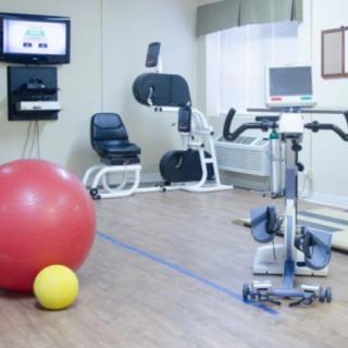 A fitness room equipped with exercise machines and stability balls.