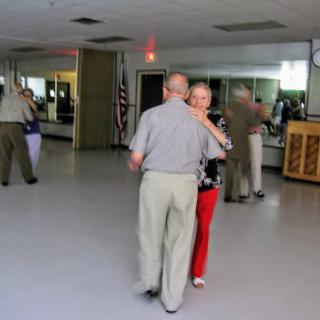A couple dances together in a dance studio.