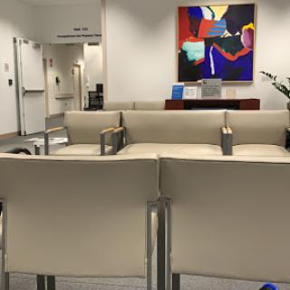 A minimalist waiting area featuring contemporary furniture and vibrant artwork.