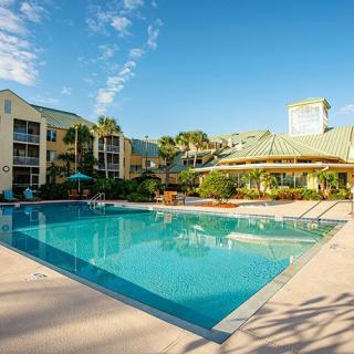 A serene resort featuring a large outdoor swimming pool under a clear blue sky.
