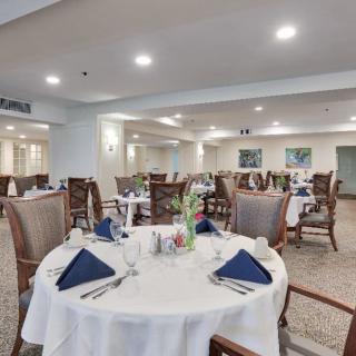 A well-arranged dining room with elegantly set tables and chairs.