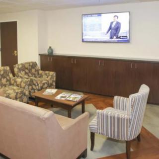 A cozy waiting room with comfortable seating and a television.