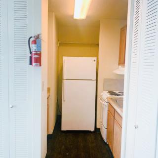 A compact kitchen with essential appliances including a refrigerator, stove, and cabinets.