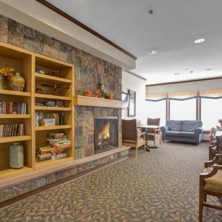 A cozy living room with a fireplace, bookshelves, and comfortable seating.