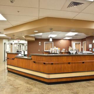 A hospital reception area with a central desk and bright lighting.
