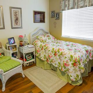 A cozy bedroom with a floral bedspread and decorative elements.