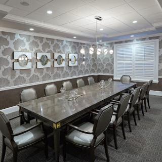A well-designed conference room featuring a long table and comfortable seating, suitable for business meetings.