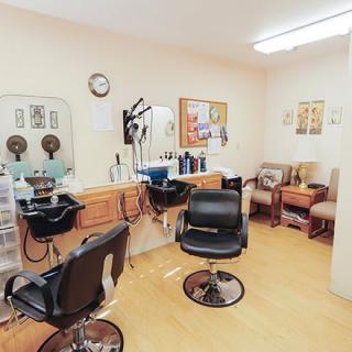 Interior of a hair salon with styling chairs and a waiting area.