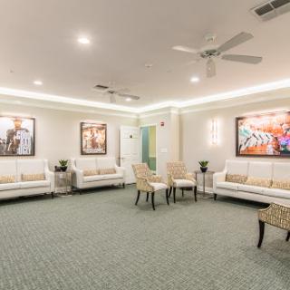 A spacious and modern lounge area featuring comfortable seating, elegant lighting, and framed artwork adorning the walls.