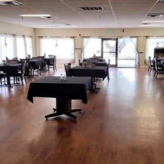 An empty restaurant interior with neatly arranged tables and chairs.