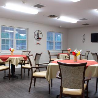 A brightly lit dining room with decorated tables and chairs.