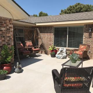 A cozy outdoor patio area with comfortable seating and decorative plants, perfect for enjoying a sunny day.