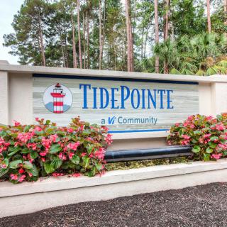 Entrance sign for TidePointe community surrounded by flowers and trees.