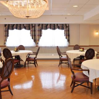 An elegant dining room setup featuring round tables and a chandelier.