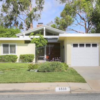A suburban single-story house with a garage and a well-maintained front yard.