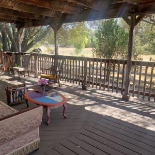 A rustic wooden porch with comfortable seating, ideal for relaxation.