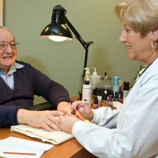 A joyful moment during a manicure session, showcasing the caring interaction between a nail technician and her client.