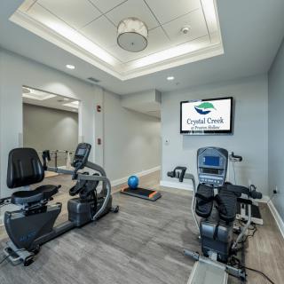 A modern fitness room equipped with stationary bikes and a treadmill.
