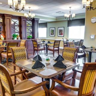 An elegantly designed dining area with neatly arranged tables and classic chandeliers.