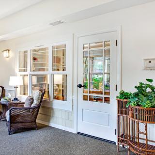 A cozy living room with comfortable seating, large windows, and indoor plants.