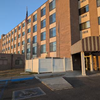 A view of a brick hotel building featuring multiple windows and handicap accessible entrance.