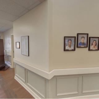 A hallway with framed photos on the wall, showcasing a cozy interior setting.