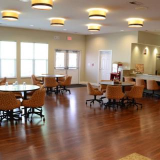 A spacious dining area with wooden flooring and modern lighting fixtures.