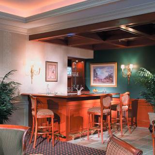 An elegant bar area with high stools and warm lighting.