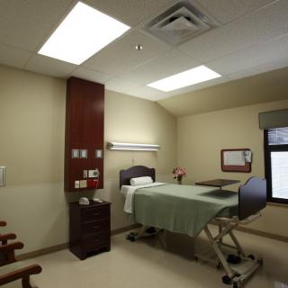 A clean and modern hospital room with a bed and medical equipment.