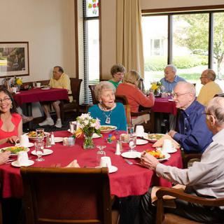 A group of elderly people enjoying a meal together at a community dining area.