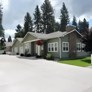 A suburban residential house with a driveway and surrounding trees.