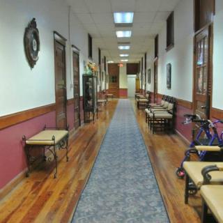 A well-lit hallway with wooden floors and benches along the sides.