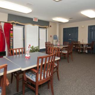 A community room with tables and chairs arranged for meetings or gatherings.