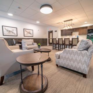 A modern living room with comfortable seating, featuring a spacious open layout connected to the kitchen.