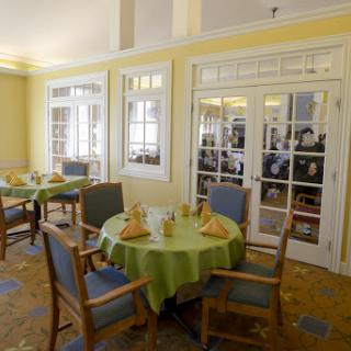 A cozy dining area featuring a well-set table and bright yellow walls.