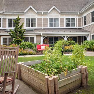 A peaceful courtyard with a raised garden bed and rocking chair.