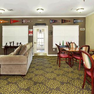 A cozy living room with a sofa, chairs, and decorative flags on the wall.