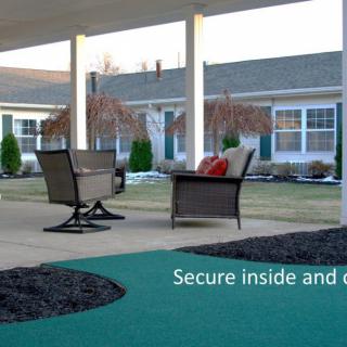 A cozy outdoor patio with comfortable seating overlooking a well-maintained garden.
